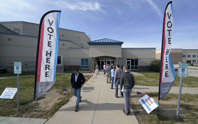 People wait to cast their ballot on the first day of early voting at an advance polling location October 17, 2020, in Overland Park, Kansas. (AP Photo/Charlie Riedel)