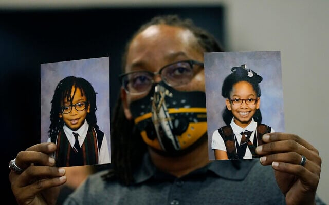 In this Tuesday, Oct. 27, 2020 photo, Sheldon Smith, center, holds the photographs of his children Deshawn Smith, 11, left, and Trinitee Smith, 13, both suffering from sickle cell anemia, during an Initiative 65 rally in Ridgeland, Miss. Smith and his wife Keishawna Smith believe their children would benefit from medical marijuana treatment for pain management. Initiative 65 would amend the Mississippi Constitution to allow the prescription by a doctor of up to 5 ounces (142 grams) of marijuana per month for people who suffer from one of more than 20 medical conditions. (AP Photo/Rogelio V. Solis) In this Tuesday, Oct. 27, 2020 photo, Sheldon Smith, center, holds the photographs of his children Deshawn Smith, 11, left, and Trinitee Smith, 13, both suffering from sickle cell anemia, during an Initiative 65 rally in Ridgeland, Miss. Smith and his wife Keishawna Smith believe their children would benefit from medical marijuana treatment for pain management. Initiative 65 would amend the Mississippi Constitution to allow the prescription by a doctor of up to 5 ounces (142 grams) of marijuana per month for people who suffer from one of more than 20 medical conditions. (AP Photo/Rogelio V. Solis)