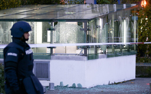 A police officer patrols in front of an entrance of a car parking with broken glasses after a shooting, in Vienna, Austria, November 3, 2020. (Ronald Zak/AP)