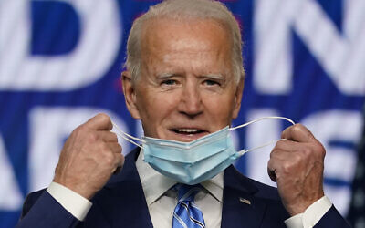 US Democratic presidential candidate former Vice President Joe Biden takes off his face mask as he arrives to speak on November 4, 2020, in Wilmington, Del. (AP Photo/Carolyn Kaster)