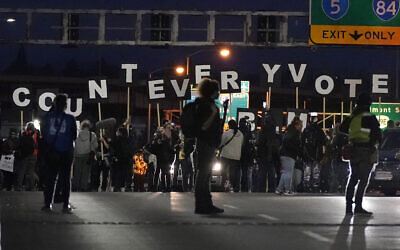Protesters hold letters that spell Count Every Vote as they cross an overpass while marching in Portland, Oregon, November 4, 2020, following the US election. (AP Photo/Marcio Jose Sanchez)
