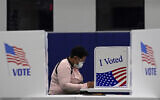 In this November 3, 2020, file photo, a woman votes at the MLB Urban Youth Academy in Kansas City, Missouri. (AP/Charlie Riedel, File)