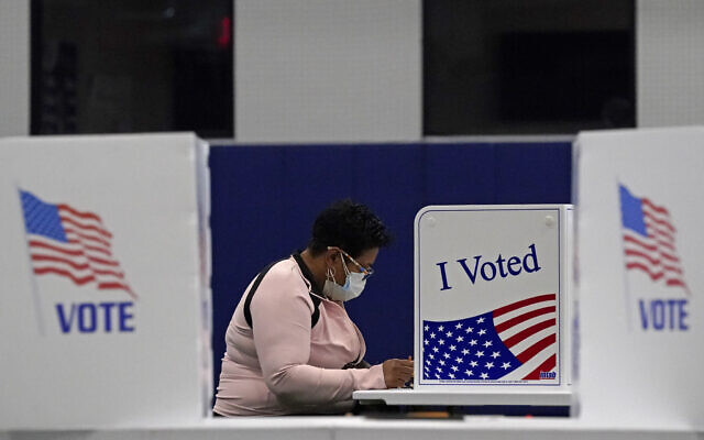 In this November 3, 2020, file photo, a woman votes at the MLB Urban Youth Academy in Kansas City, Missouri. (AP/Charlie Riedel, File) In this November 3, 2020, file photo, a woman votes at the MLB Urban Youth Academy in Kansas City, Missouri. (AP/Charlie Riedel, File)
