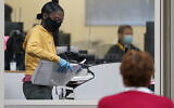 A county election worker scans mail-in ballots at a tabulating area as an observer watches at the Clark County Election Department, Thursday, Nov. 5, 2020, in Las Vegas, Nevada (AP Photo/John Locher)