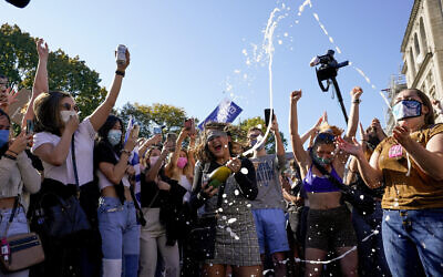 Amanda Madden sprays champagne as people celebrate at Black Lives Matter Plaza after CNN called the race in favor of Democratic presidential candidate Joe Biden over US Pres. Donald Trump, Nov. 7, 2020, in Washington (AP Photo/Alex Brandon)