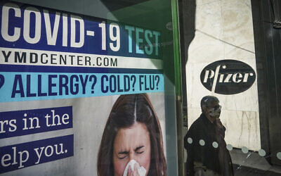 A bus stop ad for COVID-19 testing is shown outside Pfizer world headquarters in New York on Monday Nov. 9, 2020. Pfizer says an early peek at its vaccine data suggests the shots may be 90% effective at preventing COVID-19, but it doesn't mean a vaccine is imminent. (AP Photo/Bebeto Matthews)