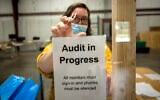 A Chatham County election official posts a sign in the public viewing area before the start of a ballot audit on November 13, 2020, in Savannah, Georgia. (AP/Stephen B. Morton)