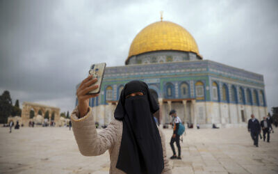 A Muslim woman takes a photo next to the Dome of the Rock Mosque in the Al Aqsa Mosque compound in Jerusalem's old city, November 6, 2020. (AP Photo/Mahmoud Illean)