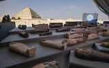 People look at ancient sarcophagi on display, discovered in a vast necropolis in Saqqara, Giza, Egypt, November 14, 2020. (AP Photo/Nariman El-Mofty)