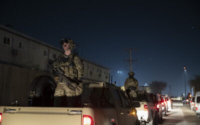 Armed US soldiers stand guard in the motorcade for President Donald Trump as he makes a surprise Thanksgiving Day visit to the troops at Bagram Air Field, Afghanistan. (AP Photo/Alex Brandon, File)