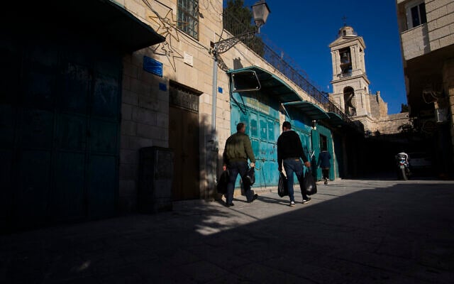 Palestinians walk past closed stores near the Church of the Nativity in the West Bank City of Bethlehem, Monday, November 23, 2020. (AP Photo/Majdi Mohammed) Palestinians walk past closed stores near the Church of the Nativity in the West Bank City of Bethlehem, Monday, November 23, 2020. (AP Photo/Majdi Mohammed)