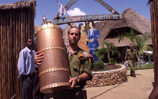 An Israeli soldier remove a Torah scroll from the Israeli-owned Paradise Hotel Friday Nov. 29, 2002, in Kikambala, near Mombassa, Kenya. The blast at the Paradise Hotel killed 10 Kenyans, three Israelis and the three suicide bombers.(AP Photo/Karel Prinsloo)