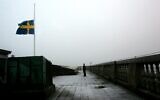 A security guard stands at attention after lowering the Swedish flag to half-staff on the roof of the Swedish parliament the Riksdag, in Stockholm, Sweden, January 1 2005. (AP Photo/Pressens Bild, Jack Mikrut)