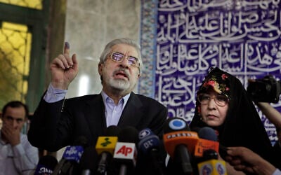 Leading challenger and reformist candidate Mir Hossein Mousavi speaks to the media after casting his vote with his wife Zahra Rahnavard, right, in the Iranian presidential elections at the Ershad mosque, on the outskirts of Tehran, Iran, June 12, 2009. (AP Photo/Ben Curtis)