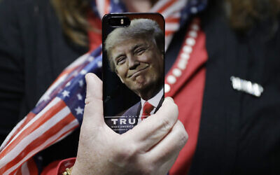 A woman holds up her cell phone before a rally with then presidential candidate Donald Trump in Bedford, New Hampshire, September 29, 2016. (AP Photo/John Locher, File)