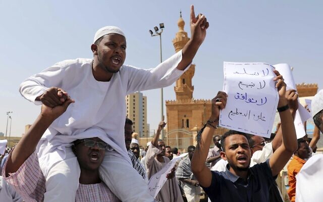 A man holds a poster with Arabic that reads, 'We will not give up, we will not sell out, we will not agree on normalization,' as others chant slogans to protest Sudanese President of the Sovereignty Council Abdel Fattah Abdelrahman Burhan's contentious decision to meet Prime Minister Benjamin Netanyahu in a move toward normalizing relations, in Khartoum, Sudan, Feb. 7, 2020. (AP Photo/Marwan Ali) A man holds a poster with Arabic that reads, 'We will not give up, we will not sell out, we will not agree on normalization,' as others chant slogans to protest Sudanese President of the Sovereignty Council Abdel Fattah Abdelrahman Burhan's contentious decision to meet Prime Minister Benjamin Netanyahu in a move toward normalizing relations, in Khartoum, Sudan, Feb. 7, 2020. (AP Photo/Marwan Ali)