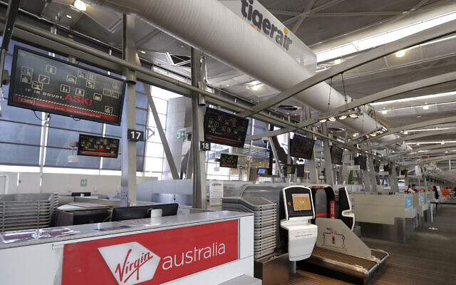 Check-in counters of Virgin Australia and Tiger Air are unattended at Sydney Airport in Sydney, Aug. 5, 2020 (AP Photo/Rick Rycroft)