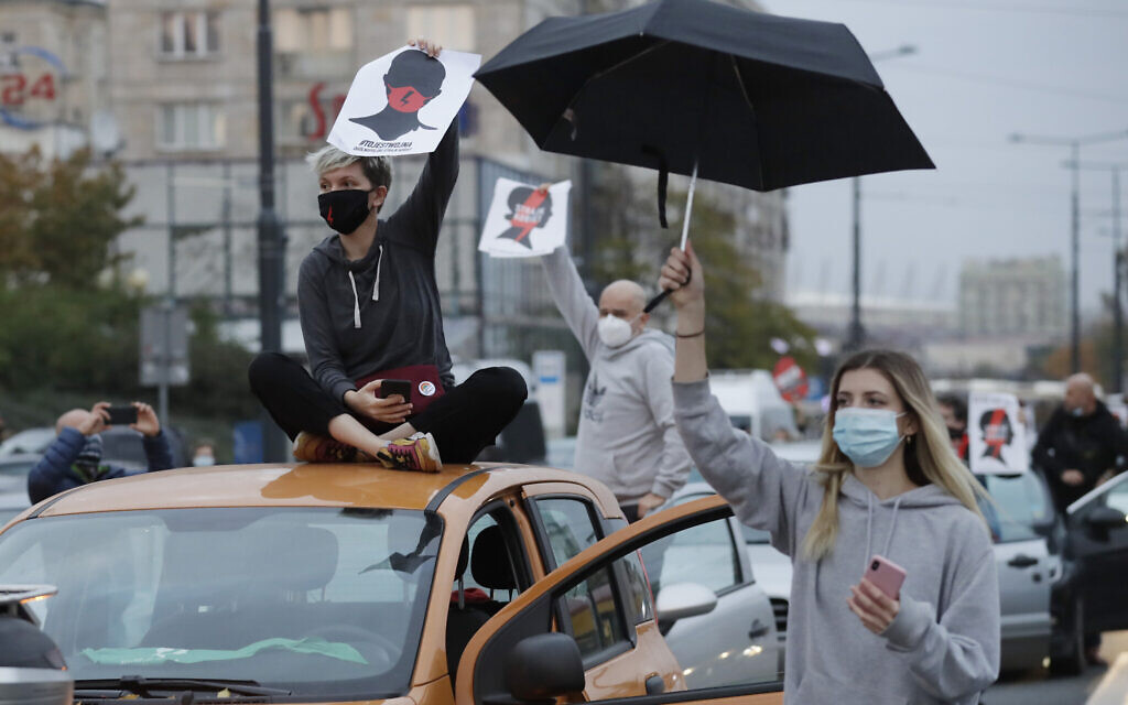 Angered women's rights activists and their supporters block rush-hour traffic at a major roundabout on the fifth day of nationwide protests against recent court ruling that tightened further Poland's restrictive abortion law, in Warsaw, Poland, on Monday, October 26, 2020. (AP Photo/Czarek Sokolowski)