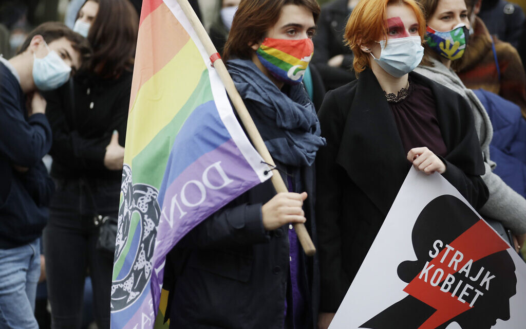 Women's rights activists protest against recent tightening of Poland's restrictive abortion law in front of the parliament building as inside, guards had to be used to shield right-wing ruling party leader Jaroslaw Kaczynski from angry opposition lawmakers, in Warsaw, Poland, on Tuesday, October 27, 2020. (AP Photo/Czarek Sokolowski)