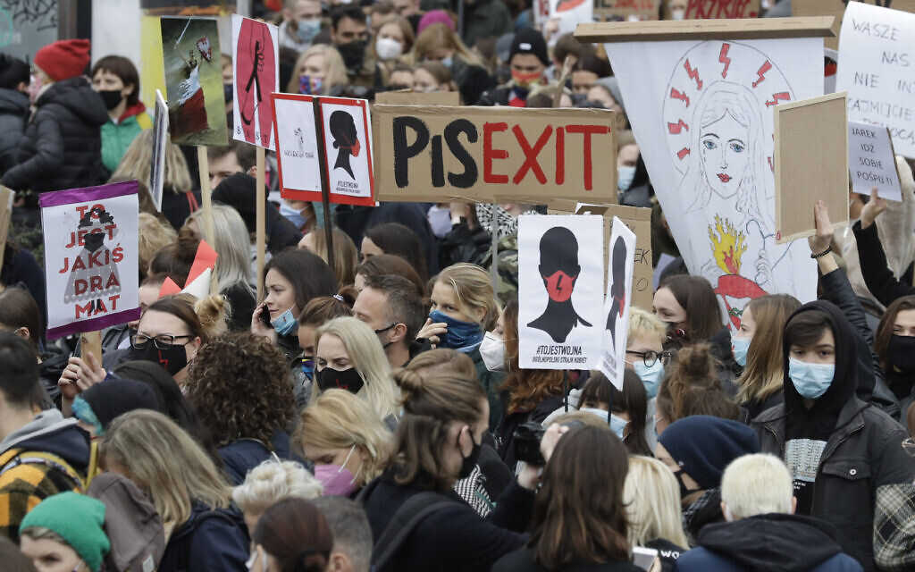 Women's rights activists hold placards during a protest in Warsaw, Poland, Wednesday, October 28, 2020 against recent tightening of Poland's restrictive abortion law. (AP Photo/Czarek Sokolowski)