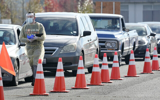 A worker wears PPE as he walks along a line of cars, Oct. 28, 2020, at a King County COVID-19 testing site in Auburn, Washington (AP Photo/Ted S. Warren) A worker wears PPE as he walks along a line of cars, Oct. 28, 2020, at a King County COVID-19 testing site in Auburn, Washington (AP Photo/Ted S. Warren)