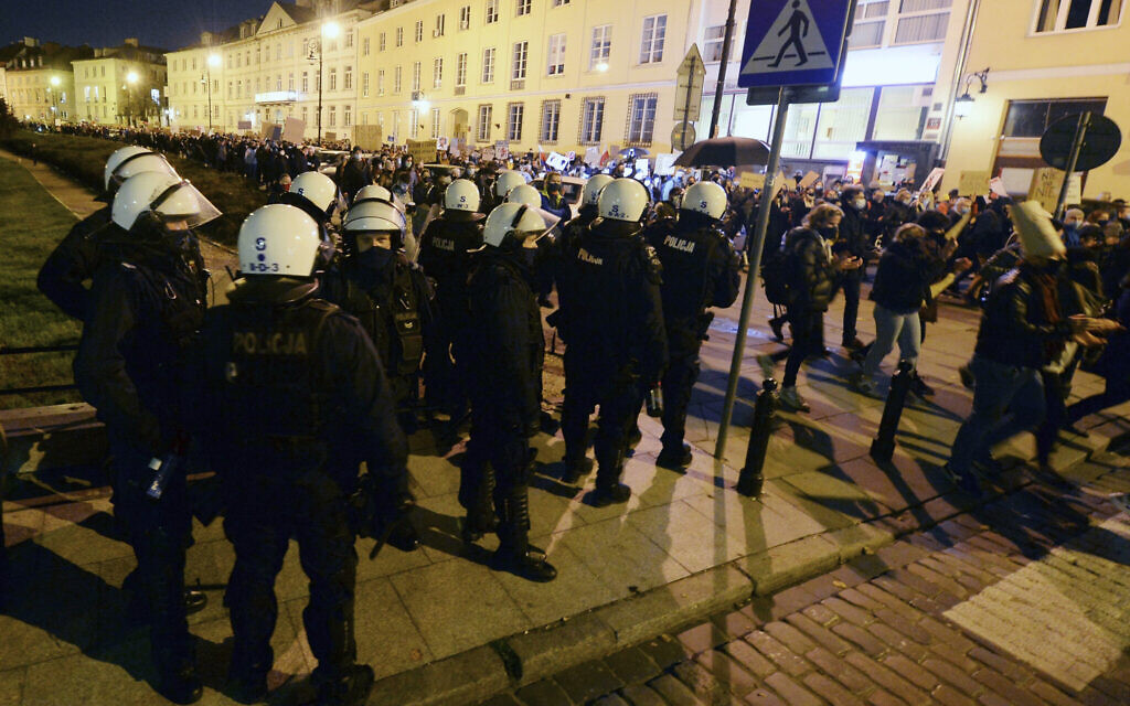 Police stand by a protest against the conservative government, on the eighth straight day of angry demonstrations triggered by a recent tightening of the abortion law, in the Old Town, in Warsaw, Poland, Friday, October 30, 2020. (AP Photo/Czarek Sokolowski)