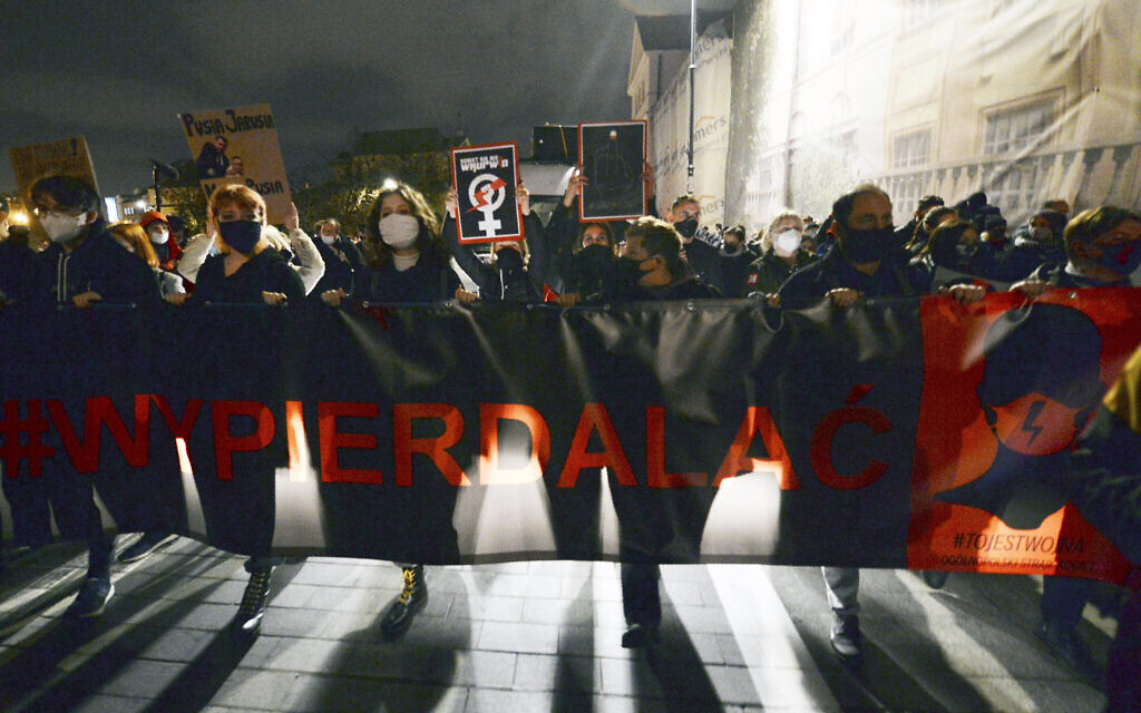 Young people take part in a protest against the conservative government, on the eighth straight day of angry demonstrations triggered by a recent tightening of the abortion law, in the Old Town, in Warsaw, Poland, Friday, October 30, 2020. (AP Photo/Czarek Sokolowski)