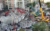 In this photo taken with a drone members of rescue services search for survivors in the debris of collapsed buildings in Izmir, Turkey, Oct. 31, 2020 (Ali Aksoyer/DHA via AP)