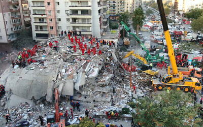 In this photo taken with a drone members of rescue services search for survivors in the debris of collapsed buildings in Izmir, Turkey, Oct. 31, 2020 (Ali Aksoyer/DHA via AP)