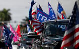 A man wearing a flag-themed body stocking waves from a car as hundreds of vehicles gather at Tropical Park ahead of a car caravan in support of US President Donald Trump, in Miami, November 1, 2020. (AP/Rebecca Blackwell)