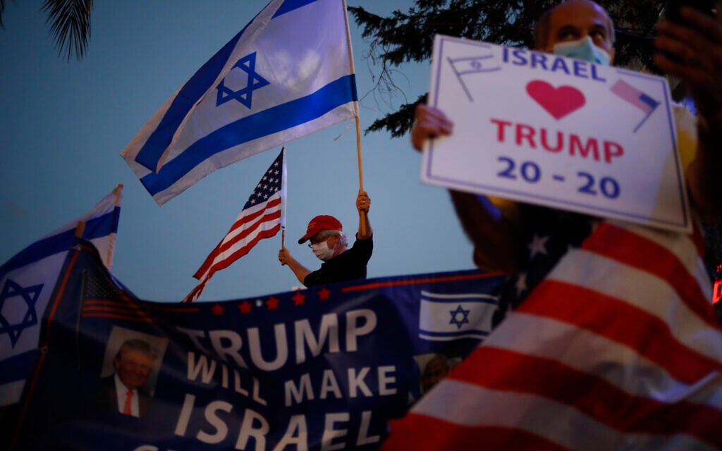 Supporters of US President Donald Trump wave Israeli and US national flags in Carmiel, northern Israel, Tuesday, November 3, 2020. (AP/Ariel Schalit)