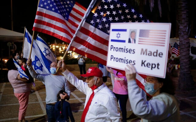 Supporters of US President Donald Trump wave Israeli and US national flags and carry placards in support, on the day of the US presidential election, in Carmiel, northern Israel, Tuesday, Nov. 3, 2020. (AP/Ariel Schalit) Supporters of US President Donald Trump wave Israeli and US national flags and carry placards in support, on the day of the US presidential election, in Carmiel, northern Israel, Tuesday, Nov. 3, 2020. (AP/Ariel Schalit)
