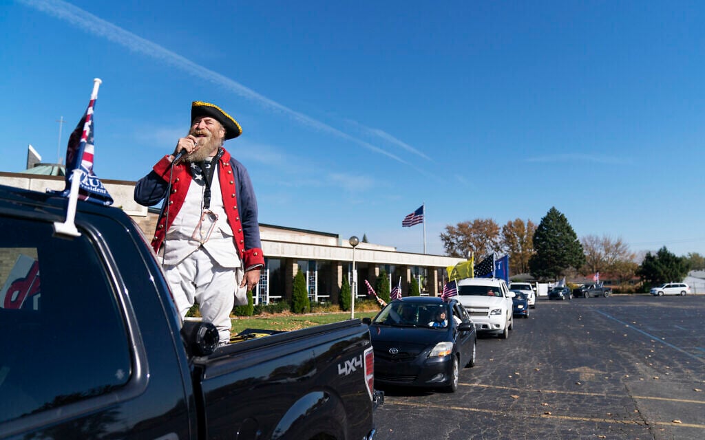 Trump supporter Matthew Woods, dressed as a Continental Army soldier, leads a Trump Train Rally through the parking lot of a polling precinct on Election Day in Warren, Mich., Tuesday, Nov. 3, 2020. (AP/David Goldman)