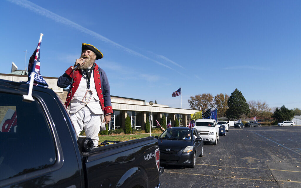 Trump supporter Matthew Woods, dressed as a Continental Army soldier, leads a Trump Train Rally through the parking lot of a polling precinct on Election Day in Warren, Michigan, Tuesday, November 3, 2020. (AP/David Goldman)