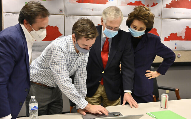 Republican Senate candidate Sen. Mitch McConnell, second from right, and his wife, Elaine Chao, right, look on as aides show him the election results in Louisville, Kentucky, Nov. 3, 2020. (AP Photo/Timothy D. Easley) Republican Senate candidate Sen. Mitch McConnell, second from right, and his wife, Elaine Chao, right, look on as aides show him the election results in Louisville, Kentucky, Nov. 3, 2020. (AP Photo/Timothy D. Easley)