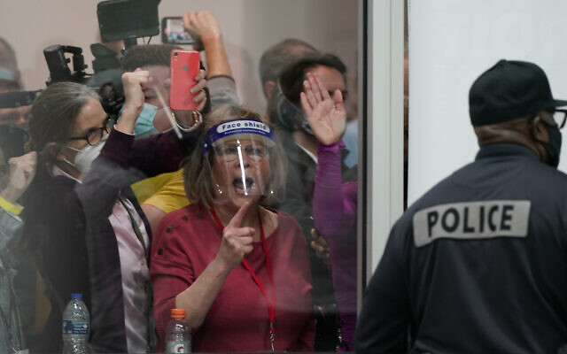 Election challengers yell as they look through the windows of the central counting board as police were helping to keep additional challengers from entering due to overcrowding, Wednesday, Nov. 4, 2020, in Detroit. (AP Photo/Carlos Osorio) Election challengers yell as they look through the windows of the central counting board as police were helping to keep additional challengers from entering due to overcrowding, Wednesday, Nov. 4, 2020, in Detroit. (AP Photo/Carlos Osorio)