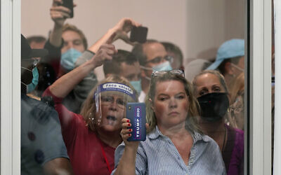 People wanting to be election challengers yell as they look through the windows of the central counting board as police were helping to keep additional challengers from entering due to overcrowding, November 4, 2020, in Detroit. (AP Photo/Carlos Osorio)