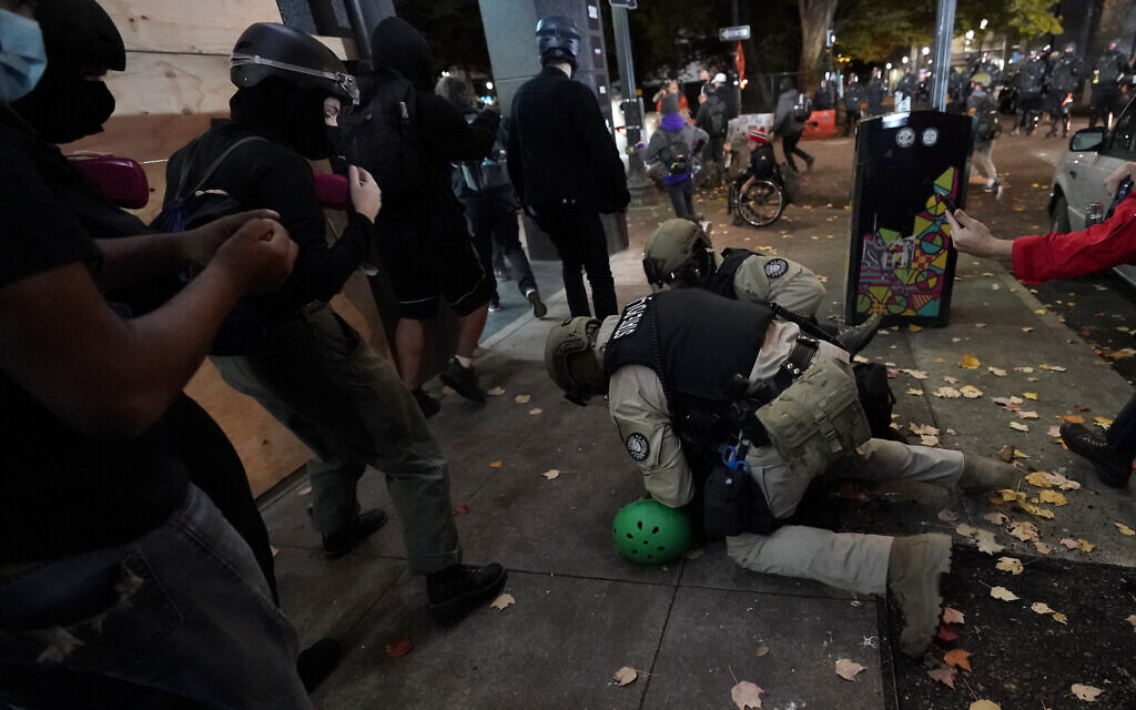 Oregon State Police arrest a protester in Portland, Ore., Wednesday, Nov. 4, 2020, following Tuesday's election. (AP Photo/Marcio Jose Sanchez)