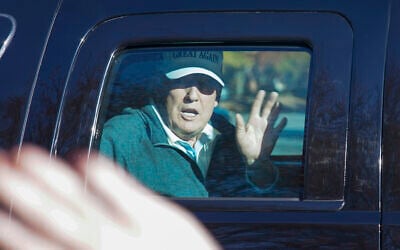 US President Donald Trump waves to supporters as he departs after playing golf at the Trump National Golf Club in Sterling Va., Sunday Nov. 8, 2020. (AP Photo/Steve Helber)