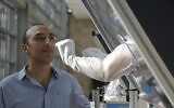 A technician demonstrates on an airport staffer how samples are taken, at a new on-site COVID-19 testing facility at Ben Gurion International Airport, November 9, 2020. (Maya Alleruzzo/AP)