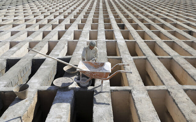 A cemetery worker prepares new graves at the Behesht-e-Zahra cemetery on the outskirts of the Iranian capital, Tehran, Iran, Nov. 1, 2020 (AP Photo/Ebrahim Noroozi)