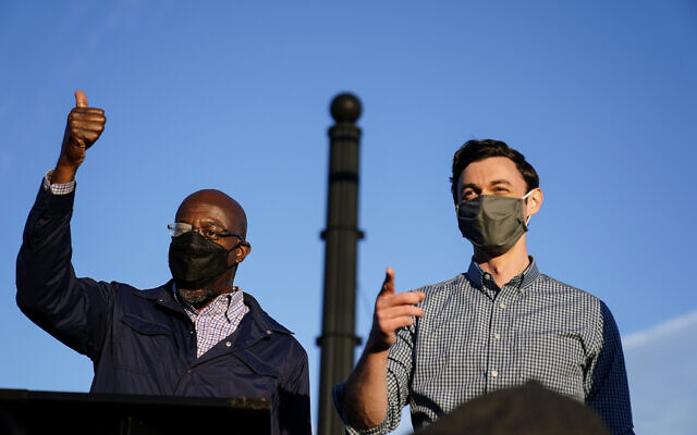 Georgia Democratic candidates for US Senate Raphael Warnock, left, and Jon Ossoff, right, gesture toward a crowd during a campaign rally on November 15, 2020, in Marietta, Ga. (AP/Brynn Anderson) Georgia Democratic candidates for US Senate Raphael Warnock, left, and Jon Ossoff, right, gesture toward a crowd during a campaign rally on November 15, 2020, in Marietta, Ga. (AP/Brynn Anderson)
