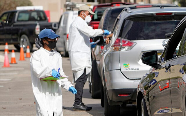 In this Nov. 19, 2020, file photo, healthcare workers process people waiting in line at a United Memorial Medical Center COVID-19 testing site in Houston. The surge of coronavirus is taking an increasingly grim toll across the United States, even as of a vaccine appears close at hand. (AP Photo/David J. Phillip) In this Nov. 19, 2020, file photo, healthcare workers process people waiting in line at a United Memorial Medical Center COVID-19 testing site in Houston. The surge of coronavirus is taking an increasingly grim toll across the United States, even as of a vaccine appears close at hand. (AP Photo/David J. Phillip)