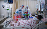 Clowns wearing protective equipment entertain a COVID-19 patient in the intensive care ward for coronavirus patients at Shaare Zedek Medical Center in Jerusalem, Nov. 23, 2020. (AP Photo/Oded Balilty)