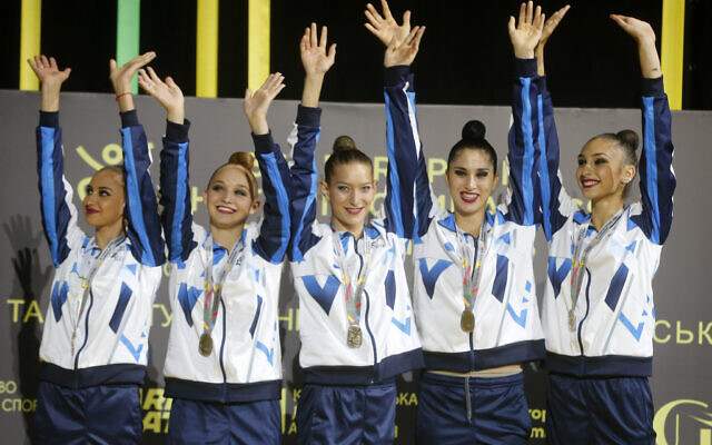 Israel's rhythmic gymnastics team wave from the podium before receiving their gold medals during the 36th European Rhythmic Gymnastics Championships in Kyiv, Ukraine, Friday, Nov. 27, 2020 (AP Photo/Efrem Lukatsky)