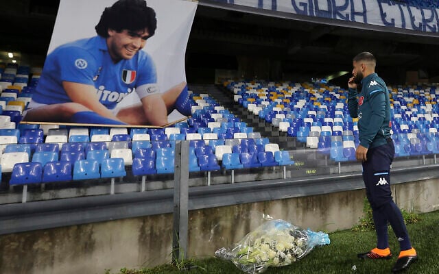 Napoli's Lorenzo Insigne lays a bouquet of flowers under a photo of Diego Armando Maradona exposed at the San Paolo stadium, November 29, 2020, prior to the Italian Serie A soccer match between Napoli and Roma, in Naples, Italy. (Alessandro Garofalo/LaPresse via AP) Napoli's Lorenzo Insigne lays a bouquet of flowers under a photo of Diego Armando Maradona exposed at the San Paolo stadium, November 29, 2020, prior to the Italian Serie A soccer match between Napoli and Roma, in Naples, Italy. (Alessandro Garofalo/LaPresse via AP)