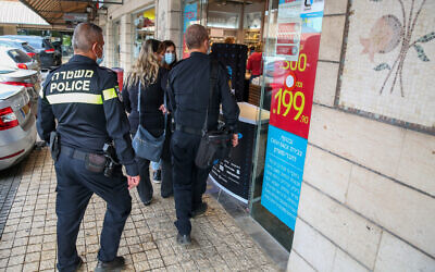 Police officers patrol outside shops during a national lockdown due to the coronavirus outbreak, in Rosh Pina on November 8, 2020. (David Cohen/Flash90)