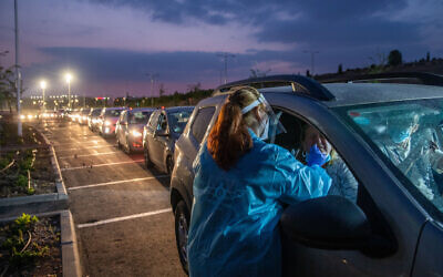 Healthcare workers take samples at a drive-through coronavirus testing site  in Modiin, on November 9, 2020 (Yossi Aloni/Flash90)