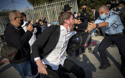 Israeli police officers try to contain a crowd of yeshiva students during the funeral of late Rabbi David Feinstein on November 9, 2020, in Jerusalem. (Yonatan Sindel/Flash90)
