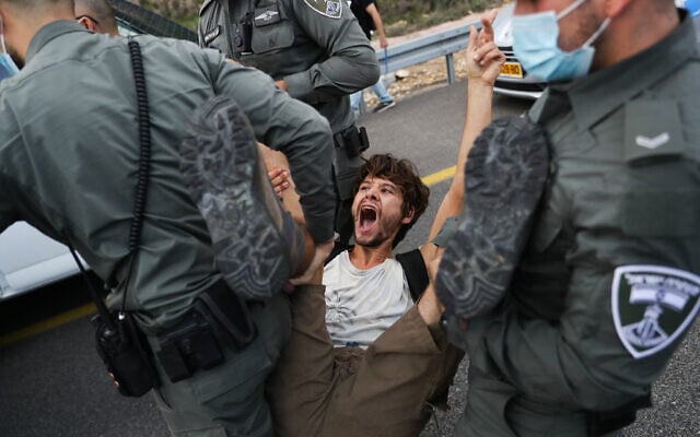 Police detain protesters as they march to Jerusalem on Highway 1 as part of a protest against Prime Minister Benjamin Netanyahu, on November 14, 2020 (Yonatan Sindel/Flash90) Police detain protesters as they march to Jerusalem on Highway 1 as part of a protest against Prime Minister Benjamin Netanyahu, on November 14, 2020 (Yonatan Sindel/Flash90)